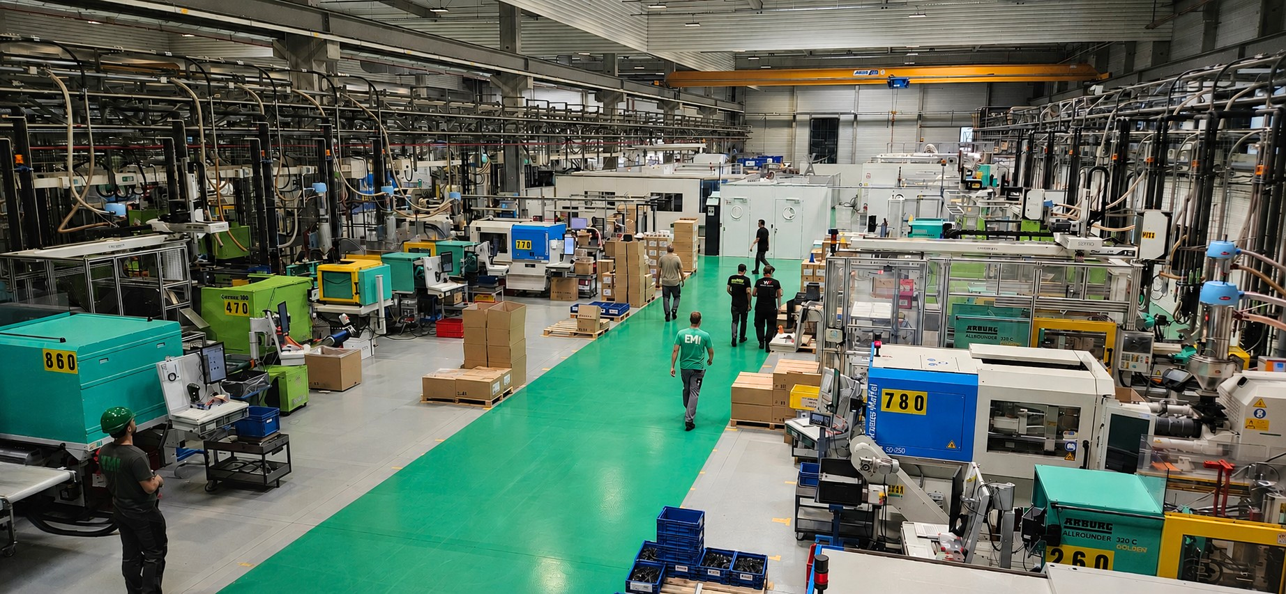 photo d'une allée de production avec des presses et des salariés marchant dans l'allée centrale